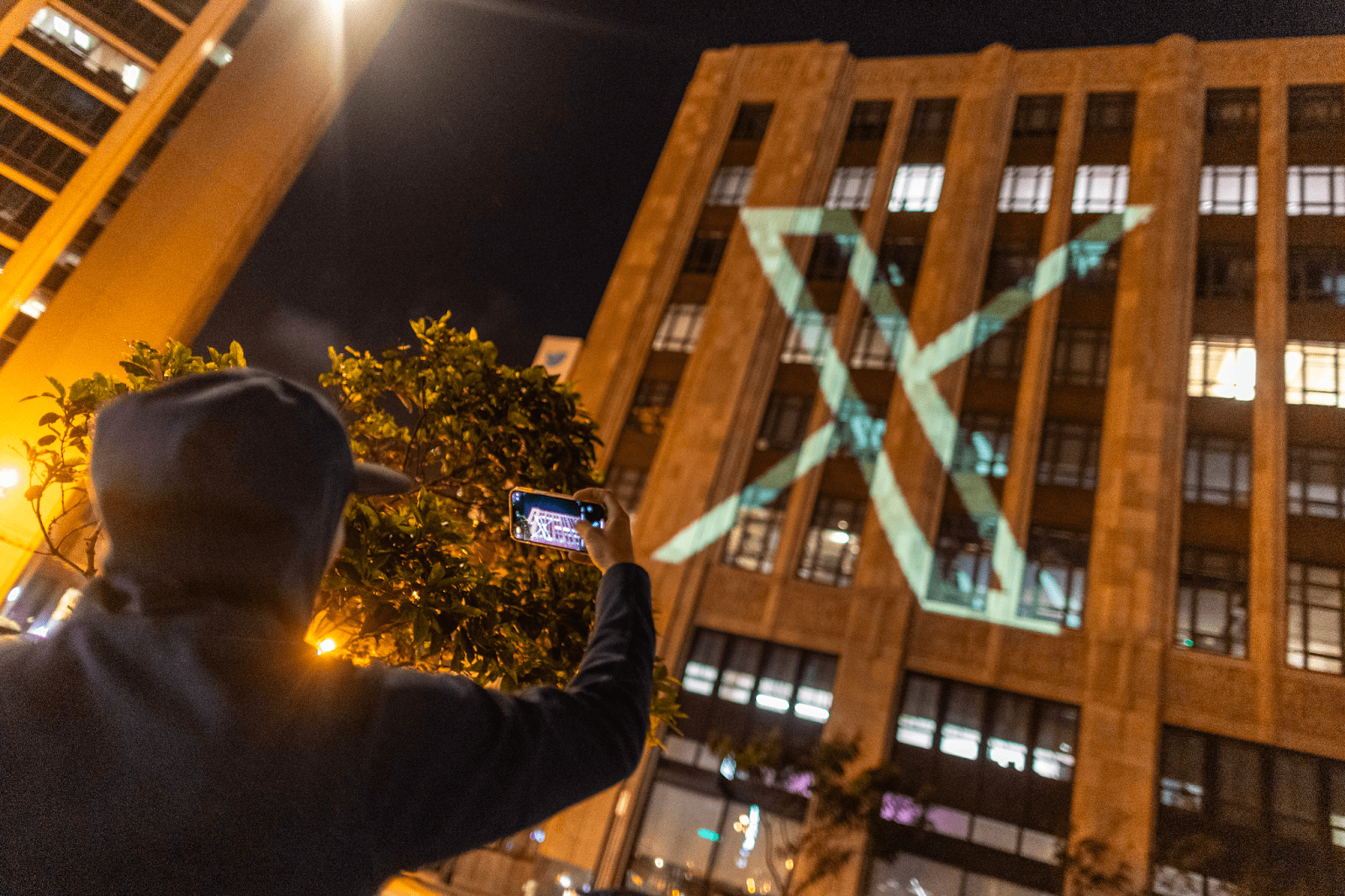 X logo projected on a building