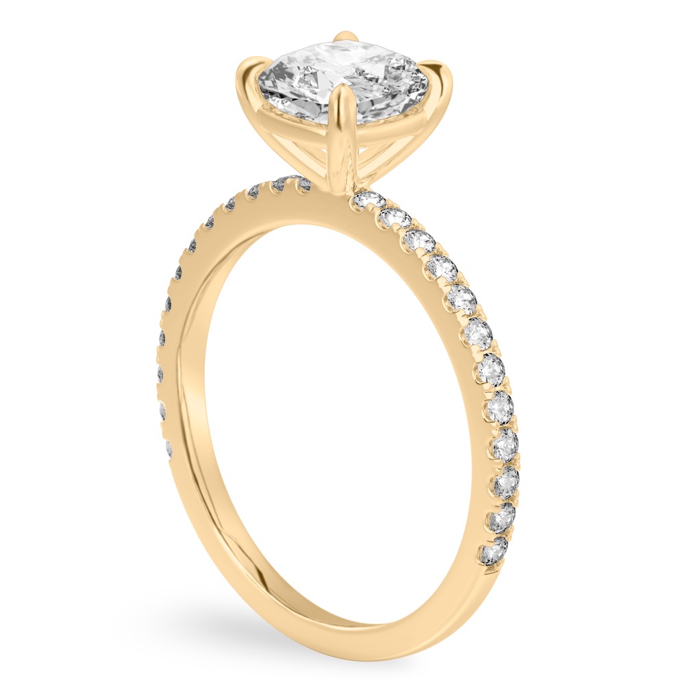 Angle view of cushion cut diamond delicate pave engagement ring in yellow gold