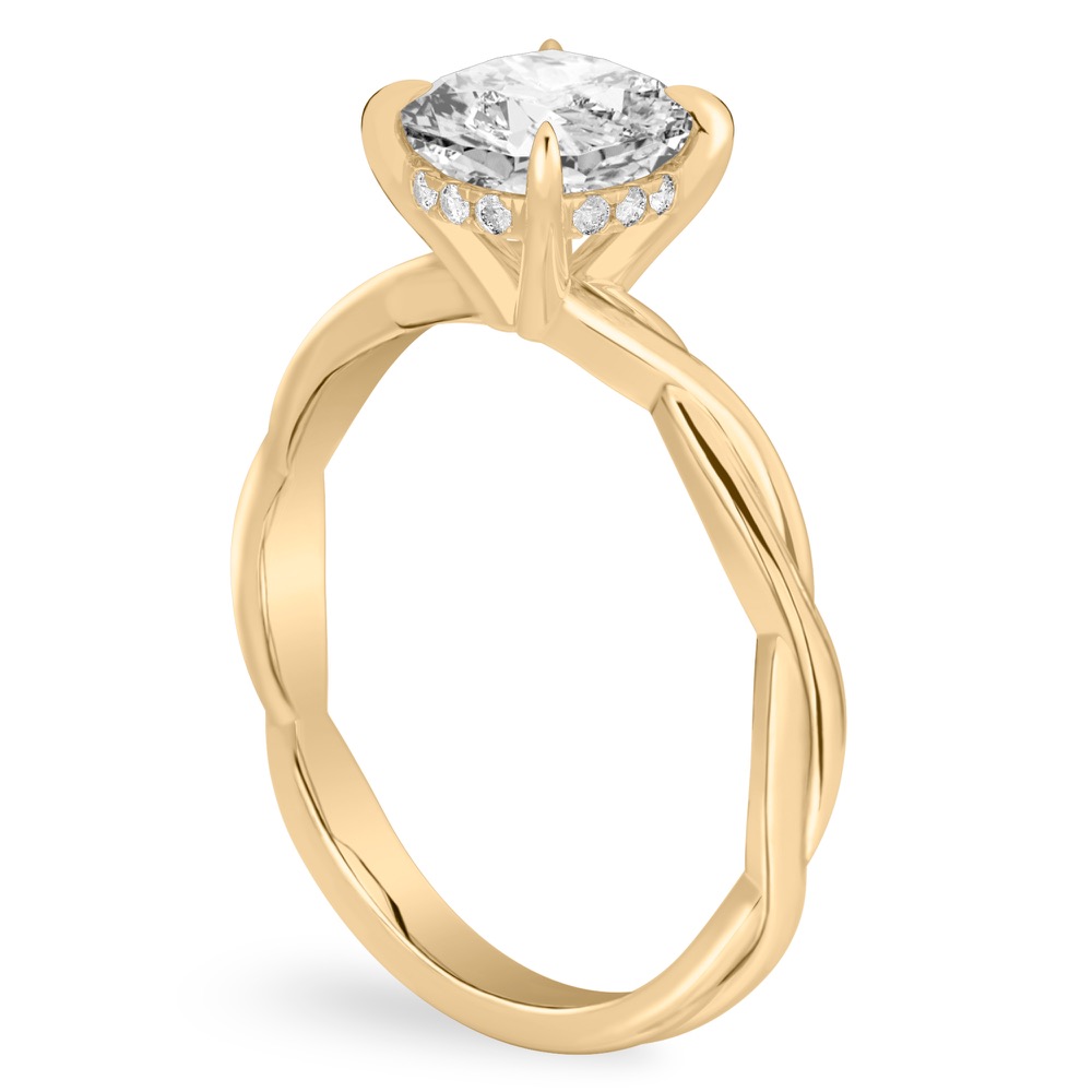 Angle view of cushion cut diamond twisted hidden halo engagement ring in yellow gold