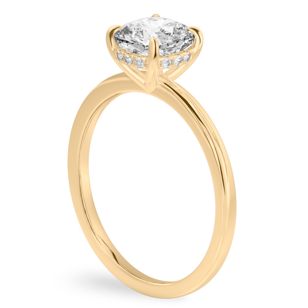 Angle view of cushion cut diamond ultra low hidden halo engagement ring in yellow gold