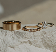 image of three yellow gold rings placed on a white stone