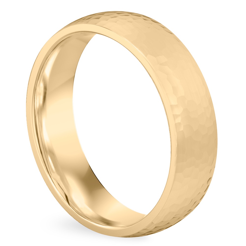 Angle view of domed hammered wedding band in yellow gold