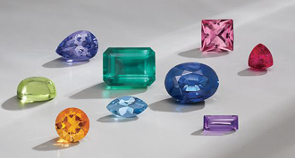 http://colorful%20gemstones%20of%20various%20shapes%20on%20white%20surface%20with%20shadows