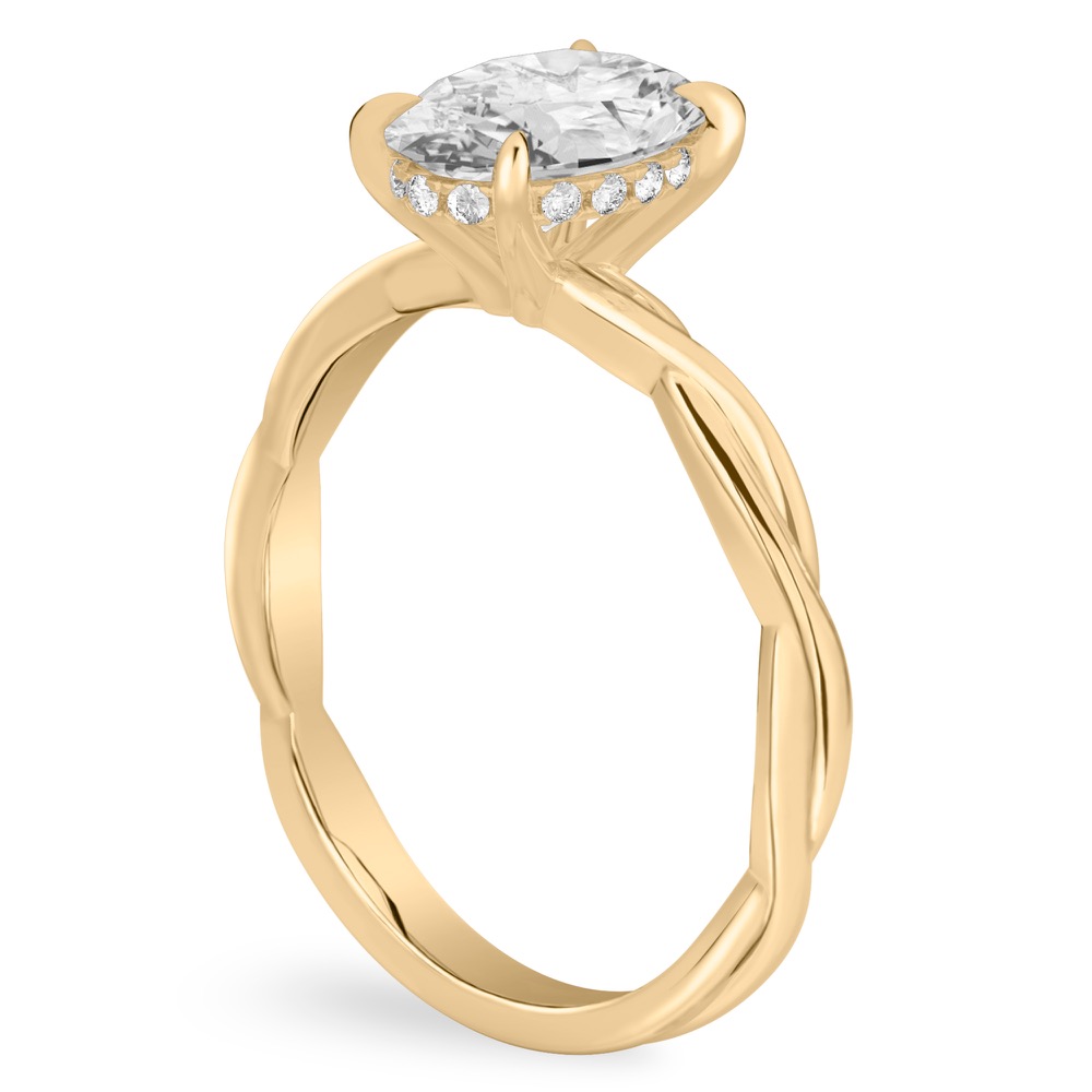 Angle view of oval shape diamond twisted hidden halo engagement ring in yellow gold