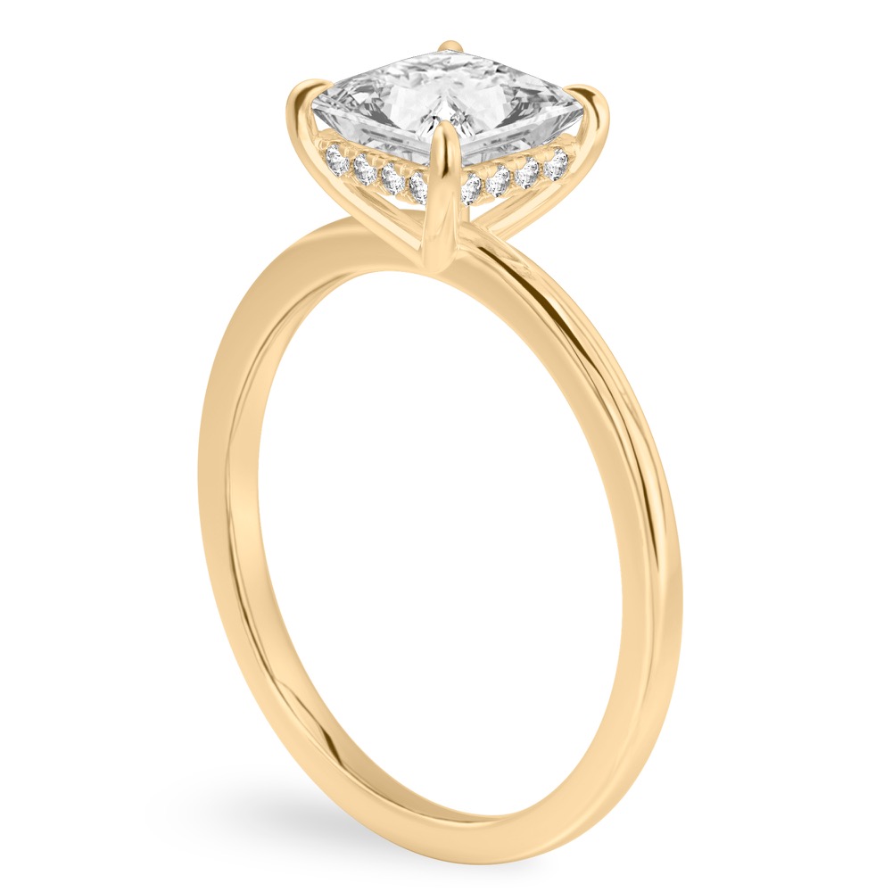 Angle view of princess cut diamond ultra low hidden halo engagement ring in yellow gold