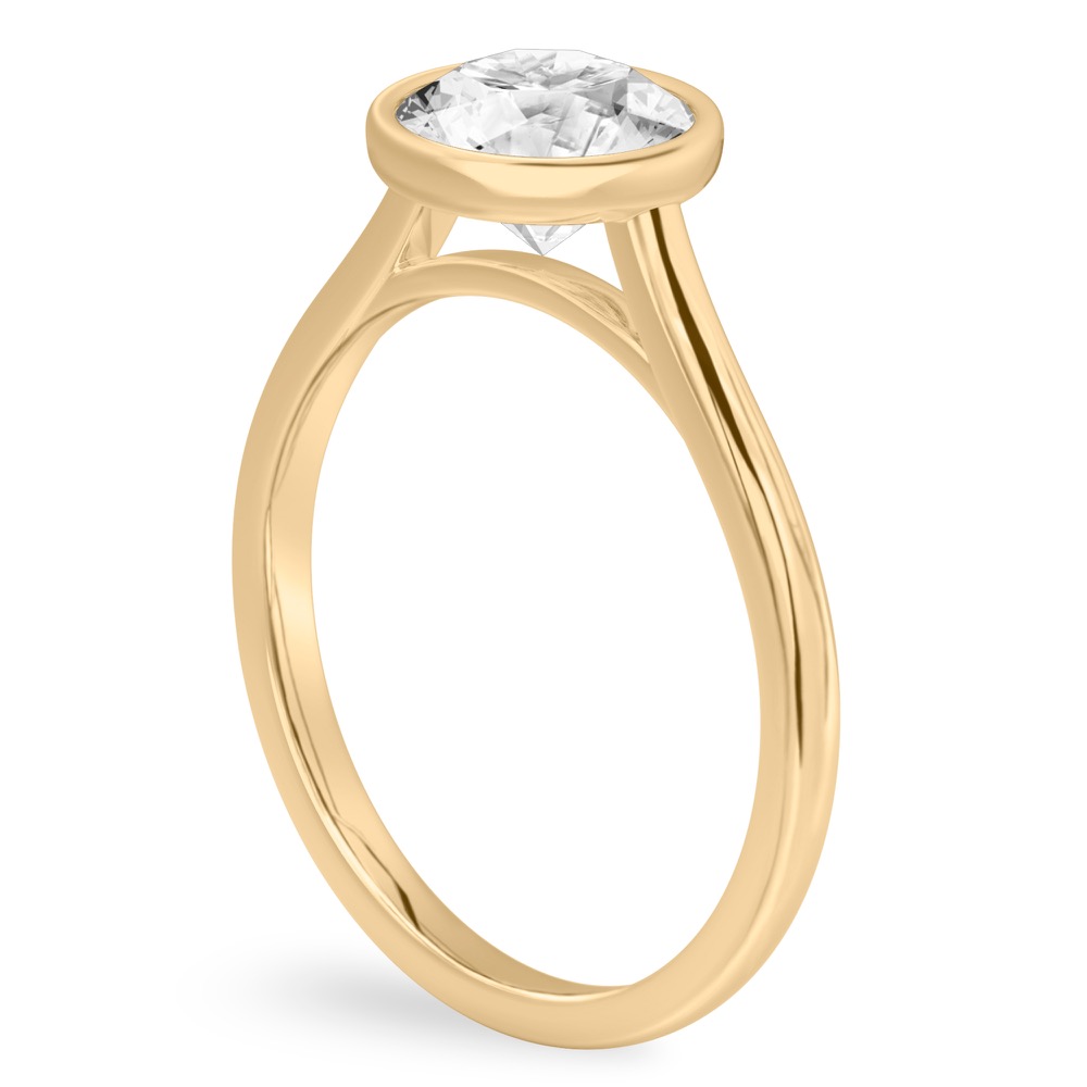 Angle view of round cut diamond bezel engagement ring in yellow gold