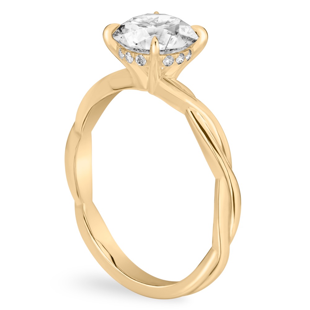 Angle view of round cut diamond twisted hidden halo engagement ring in yellow gold