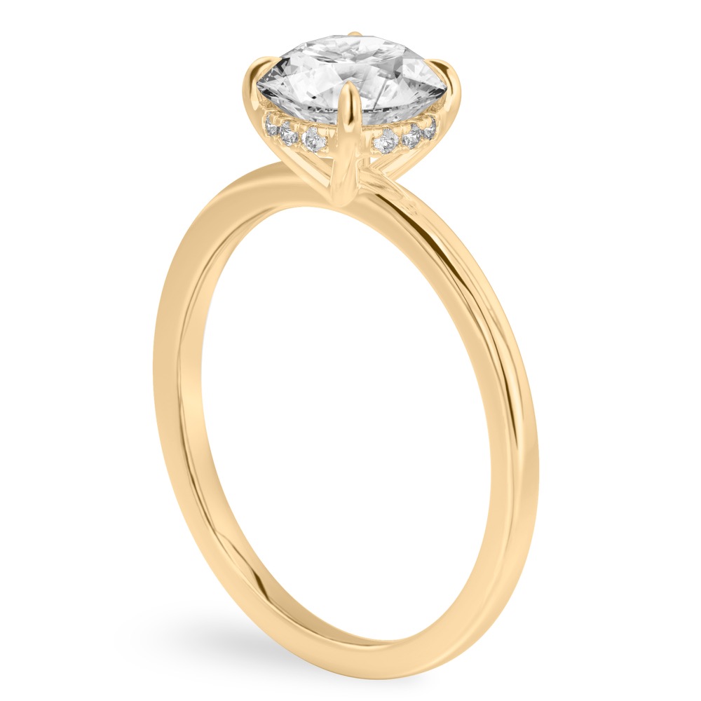 Angle view of round cut diamond ultra low hidden halo engagement ring in yellow gold